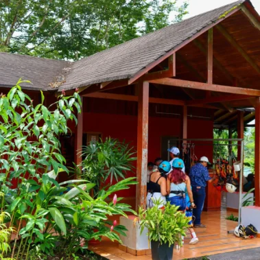 Tourists preparing with helmets and harnesses at the canopy reception area in La Fortuna near Arenal Volcano.