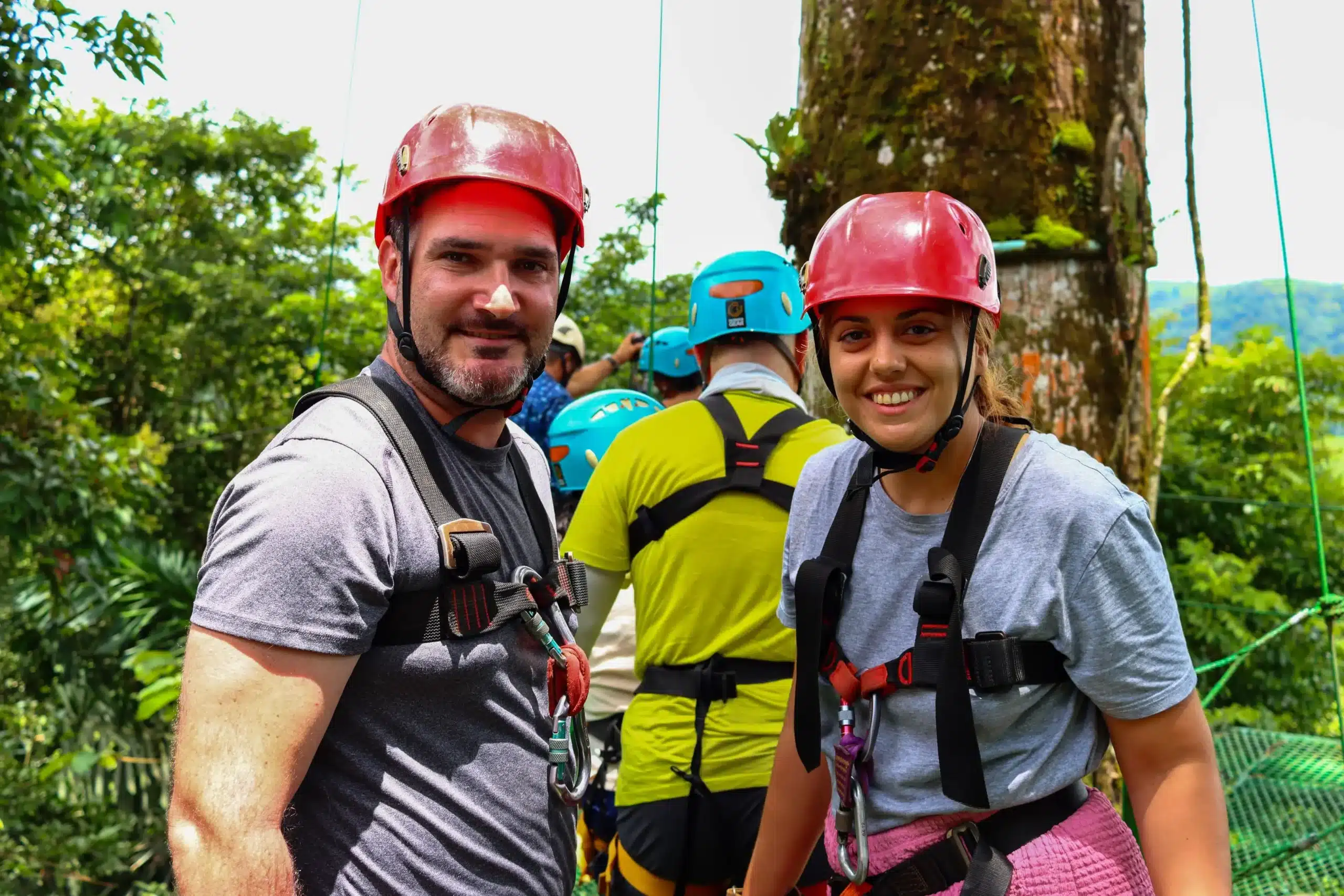 Smiling couple in helmets and harnesses ready for zipline adventure at Canopy Tour La Fortuna near Arenal Volcano Costa Rica